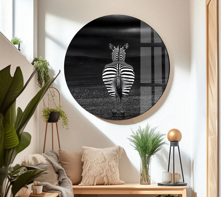 Solitary zebra in grayscale printed on glass, facing distant hills beneath a stormy sky.