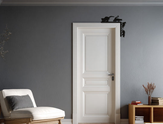 Against the textured gray wall, the Whisker Chaos playful cats metal art for wall accentuates the subdued home decor of the door and surrounding furnishings.