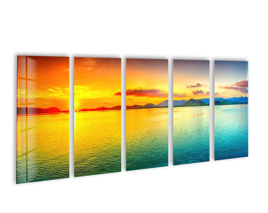 The glossy five piece glass wall art shows a yellow and blue sunset seascape and is ideal as coastal wall decor and abstract art