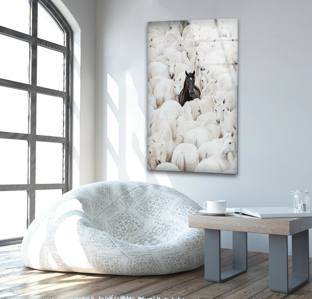 Grayscale animal artwork on glass showing individuality through the dark horse within a light-colored group.
