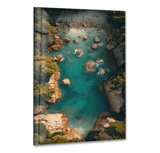 Irregular surface texture of the turquoise cove glass wall art creates a home decoration showcasing the craggy rocks and rippling waves.