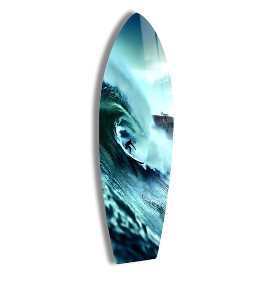 Surfboard glass wall art shows a surfer riding an ocean wave and a lighthouse in the background and this surf art is perfect for surf decor and ocean themed spaces
