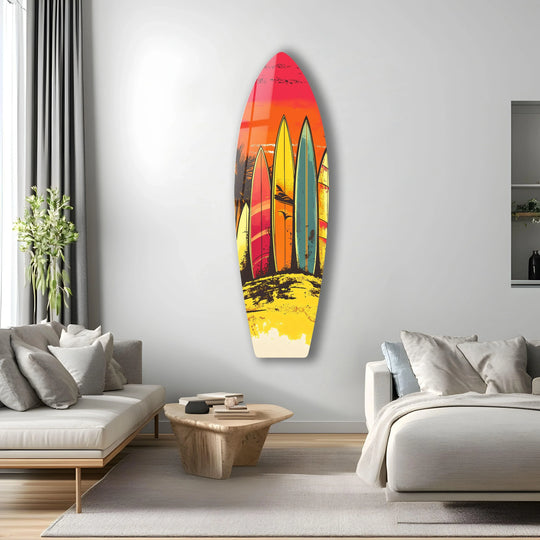 A vertical, surfboard-shaped glass art piece featuring a vibrant sunset over a beach, perfect for decorative wall art.