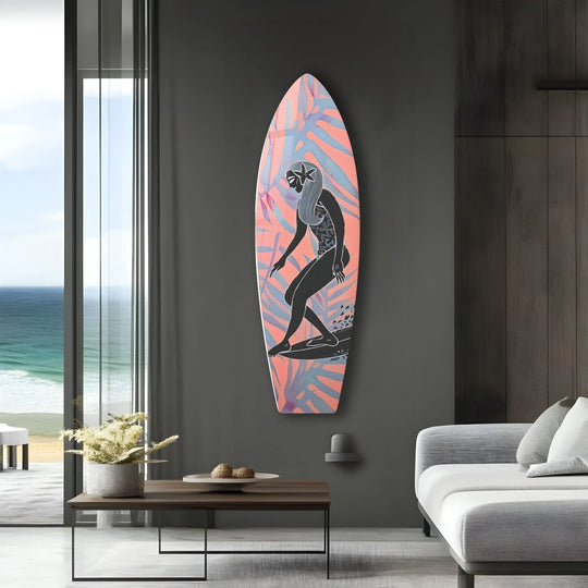 A striking surfboard with vibrant coral and pale blue leaf motifs, featuring a silhouetted surfer, adds unique modern wall decor.