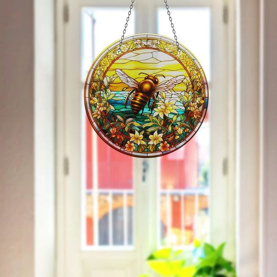 Organic forms of the bee suncatcher bring nature indoors as glass wall art decor with its floral border, wings, and a glowing sun.