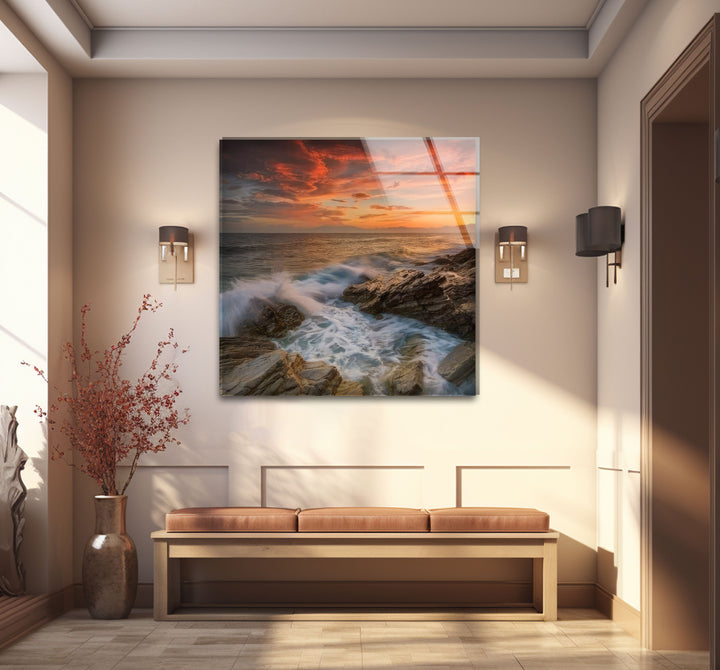 Wandkunst mit Sonnenuntergang an der Felsküste – Dramatisches Glasdruckdesign mit Meereswellen
