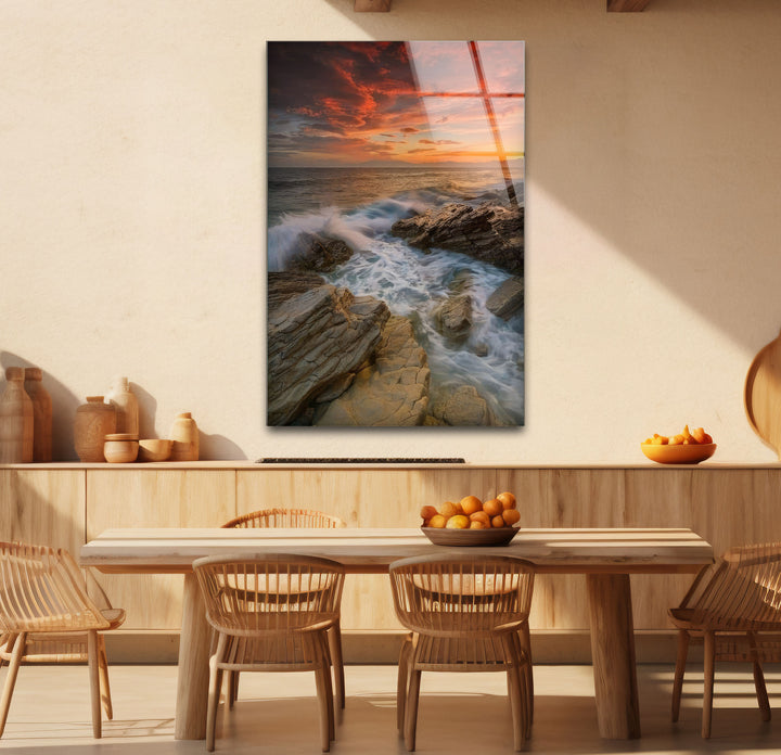 Wandkunst mit Sonnenuntergang an der Felsküste – Dramatisches Glasdruckdesign mit Meereswellen
