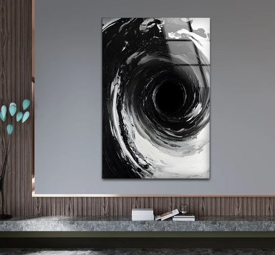 Modern abstract black and white swirling vortex glass wall art featuring a grey background and wood-paneled accent wall, perfect for home decor.