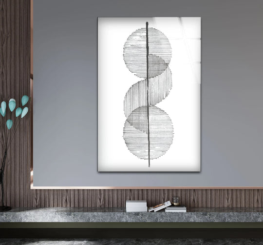 A gray wall background frames minimalist black and white art from glass with subtle texture.