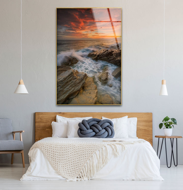 Wandkunst mit Sonnenuntergang an der Felsküste – Dramatisches Glasdruckdesign mit Meereswellen