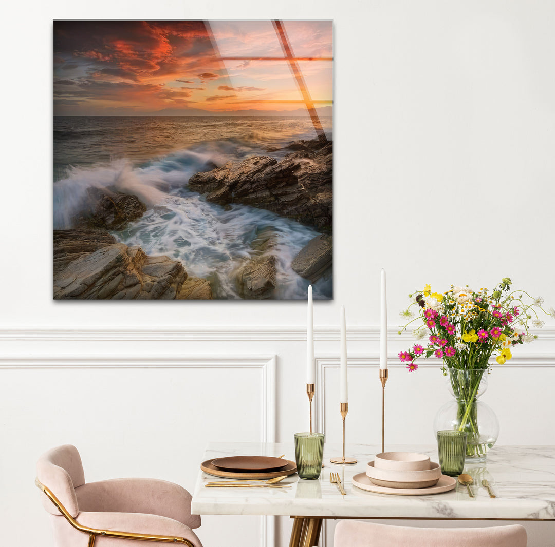 Wandkunst mit Sonnenuntergang an der Felsküste – Dramatisches Glasdruckdesign mit Meereswellen