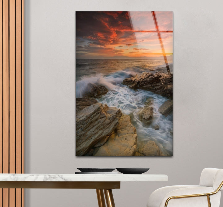Wandkunst mit Sonnenuntergang an der Felsküste – Dramatisches Glasdruckdesign mit Meereswellen