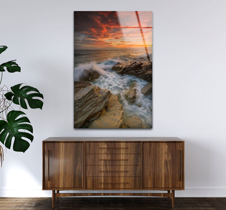 Wandkunst mit Sonnenuntergang an der Felsküste – Dramatisches Glasdruckdesign mit Meereswellen