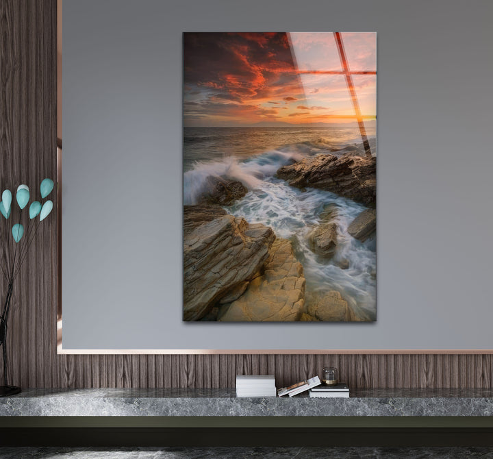 Wandkunst mit Sonnenuntergang an der Felsküste – Dramatisches Glasdruckdesign mit Meereswellen