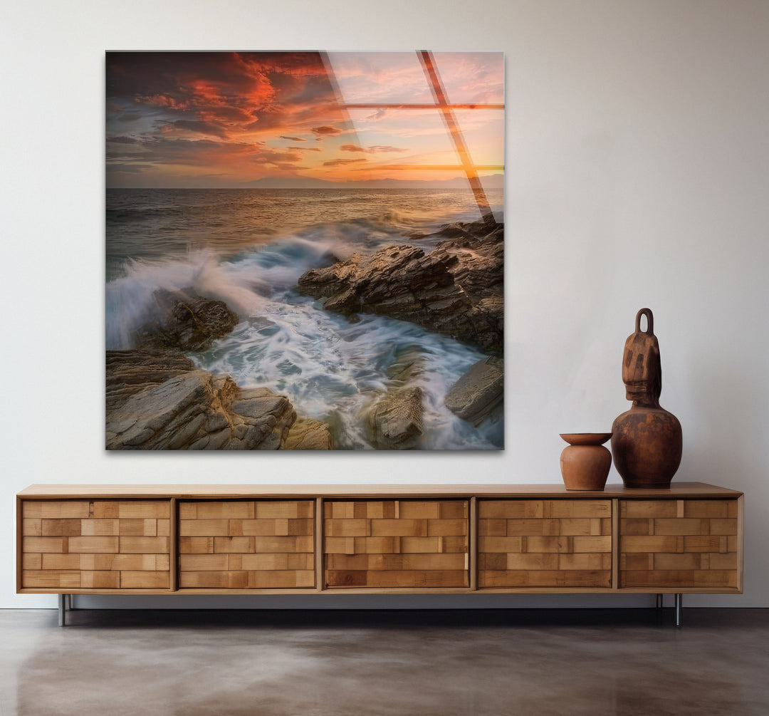 Wandkunst mit Sonnenuntergang an der Felsküste – Dramatisches Glasdruckdesign mit Meereswellen