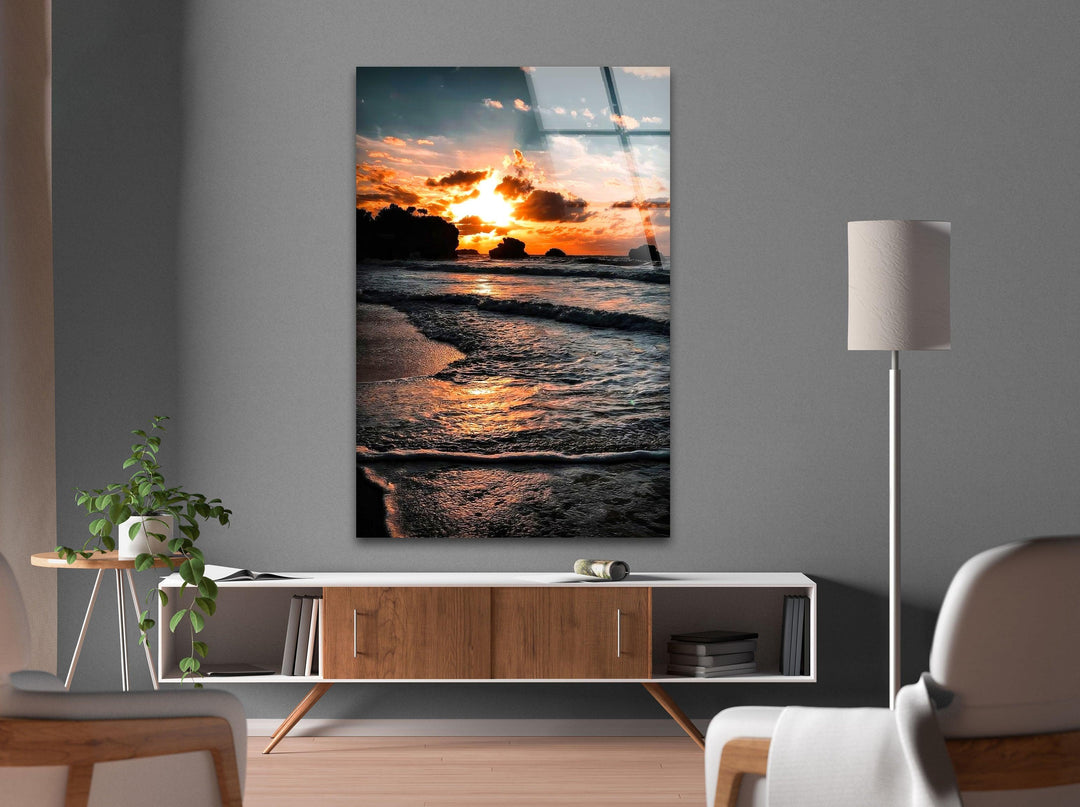 Serene coastal sunset with a golden glow reflecting across the calm waves of the beach.
