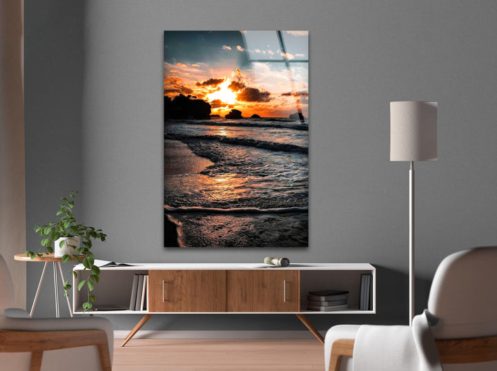Serene coastal sunset with a golden glow reflecting across the calm waves of the beach.
