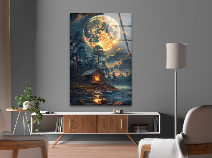 High-quality glass print of a magical full moon illuminating a rustic cabin.
