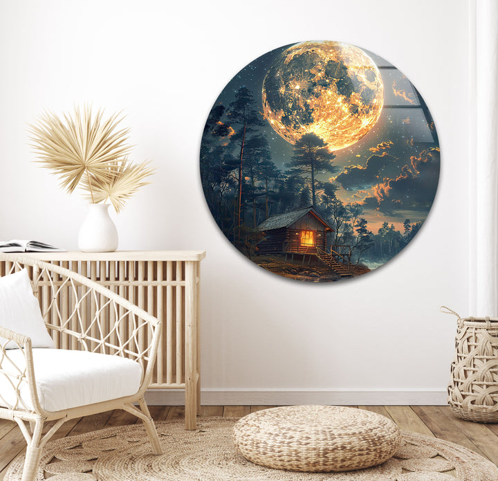 Large glass wall decor highlighting the beauty of a cabin under a golden moon.
