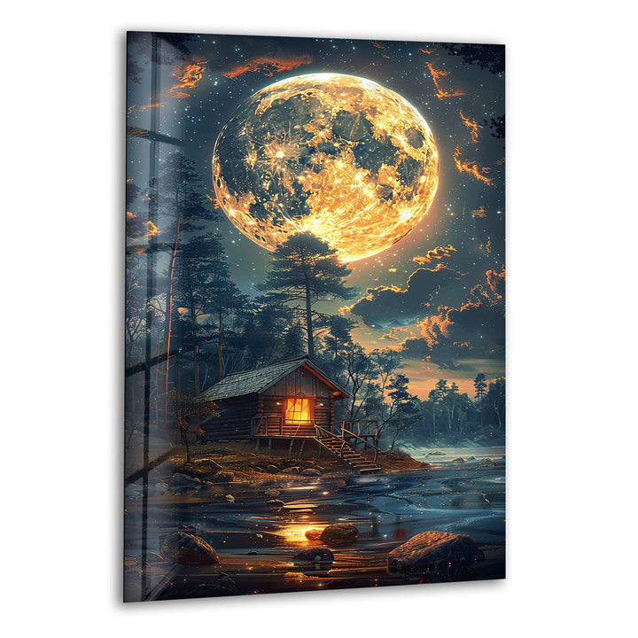 Glass wall art featuring a glowing full moon over a cozy forest cabin.
