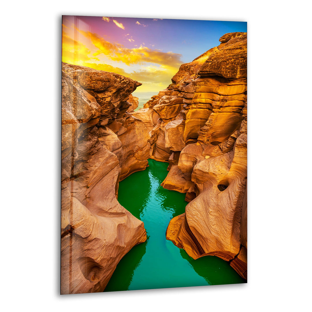 Breathtaking canyon landscape with golden rock formations and emerald-green water, printed on glass wall art.
