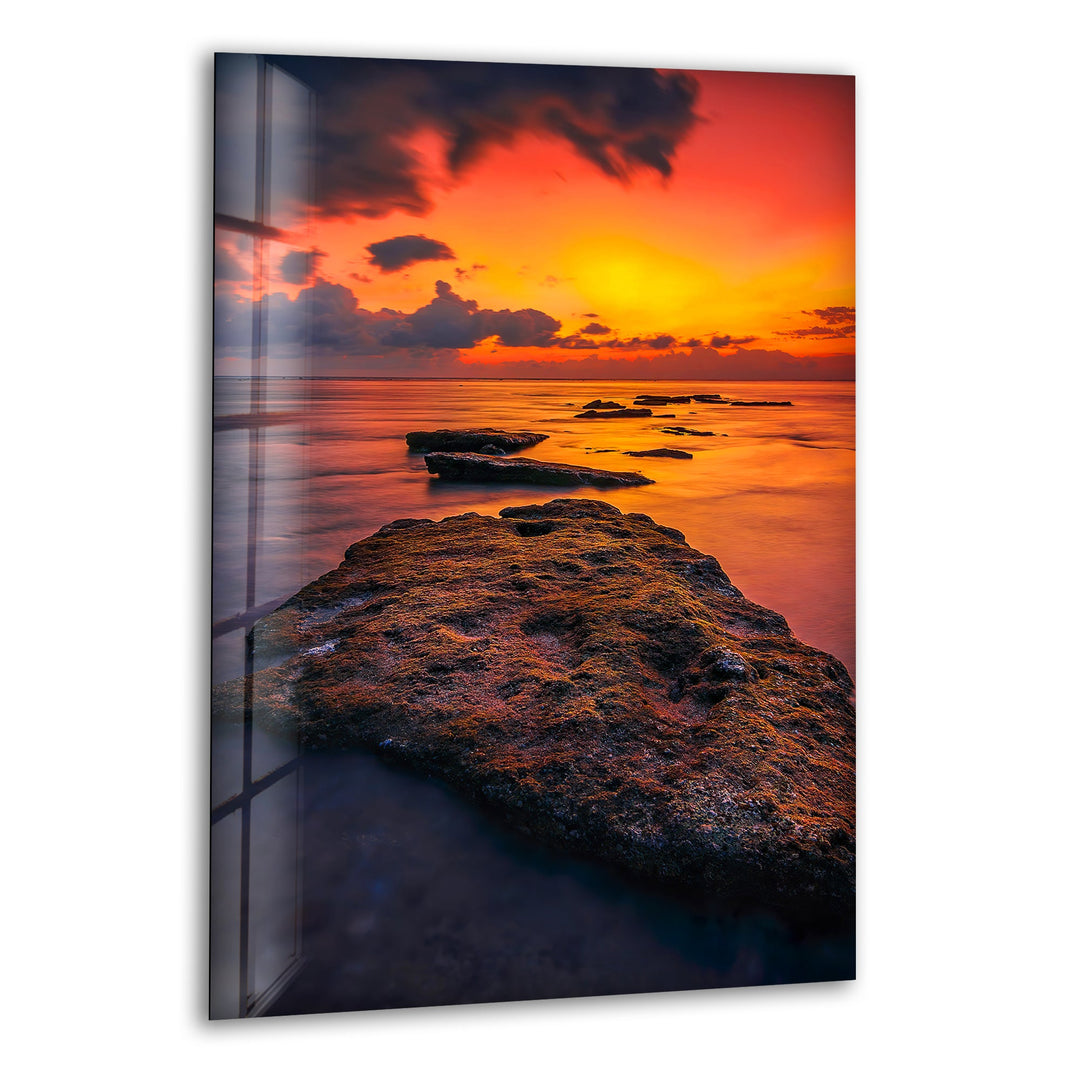 Golden sunset over a rocky coastal shoreline, printed on glass wall art.
