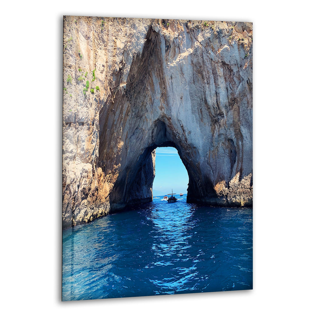 Stunning coastal rock archway over crystal-clear blue waters, printed on glass wall art.
