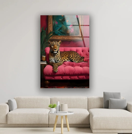 A stunning leopard lounging on a plush pink seat, with ample negative space highlighting this striking hanging wall art.