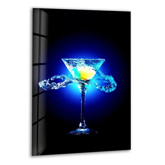 Vertical glass wall art featuring a brightly lit blue cocktail glass with splashing liquid and a lemon slice for modern kitchen decor.