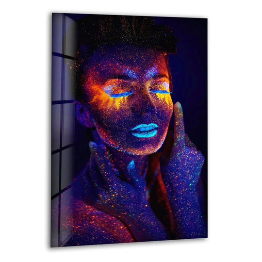 A woman's face and hands are covered in vibrant neon paint, illuminated by blacklight in this striking glass wall art.