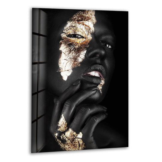 The brightest area on this gold and black woman portrait glass wall art features cracked gold leaf accents across the eye and lips.
