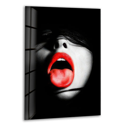 A woman's soft, parted lips with a crimson tongue emerge from darkness in this dramatic hanging wall art.