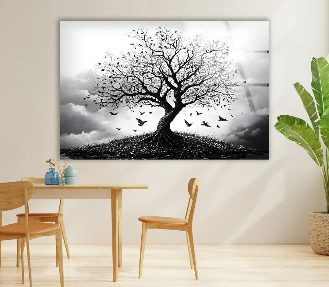 Atmospheric monochrome tree scene on glass with roots visible on a small hill and birds in motion.