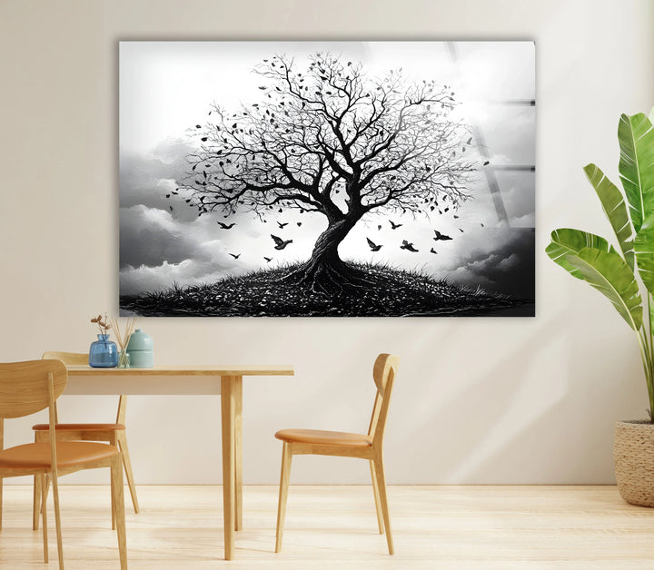 Atmospheric monochrome tree scene on glass with roots visible on a small hill and birds in motion.
