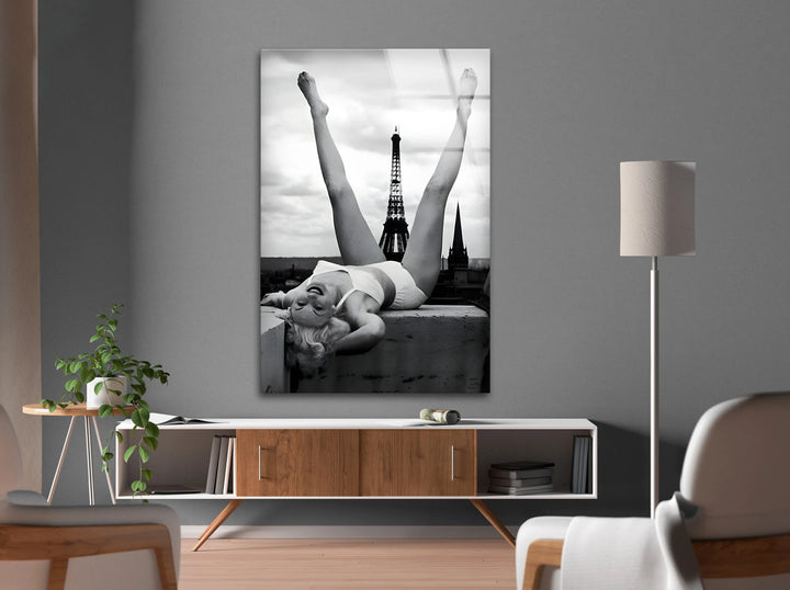 Minimalist black and white glass art of a cheerful woman posing high above Paris.