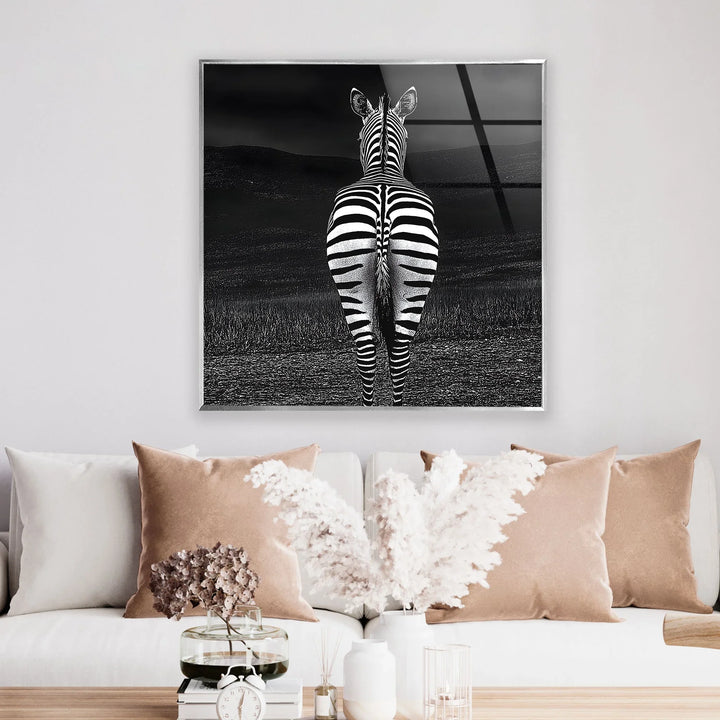 Grayscale animal scene on glass depicting a zebra’s striped back against a moody, cloud-filled sky.