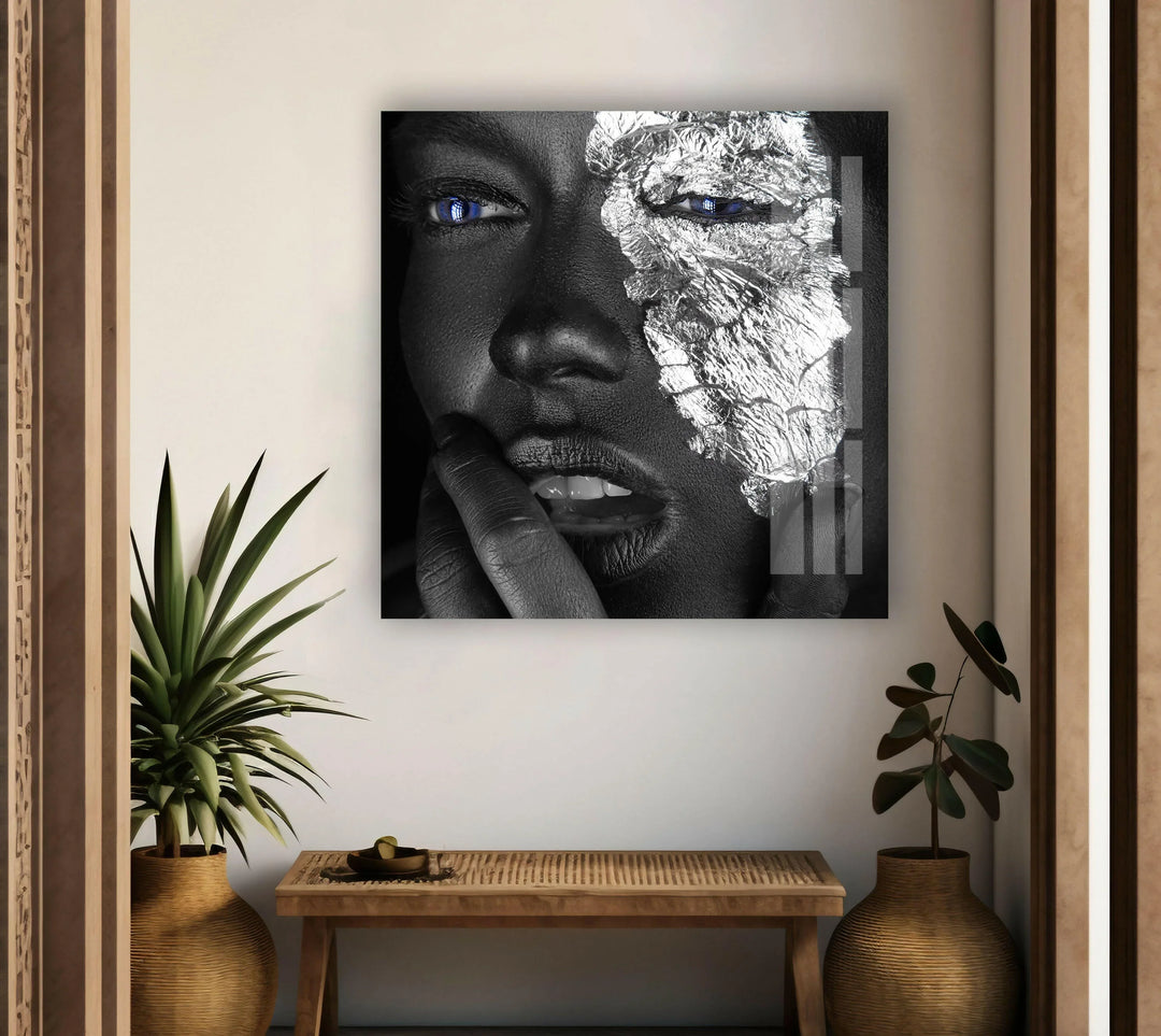 Modern monochrome glass art showing a expressive face with silver foil and piercing blue eyes.