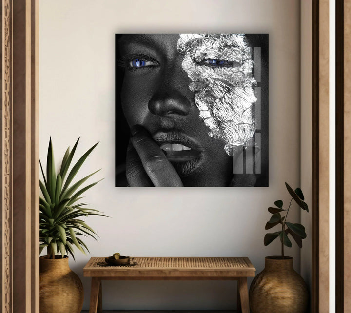 Modern monochrome glass art showing a expressive face with silver foil and piercing blue eyes.