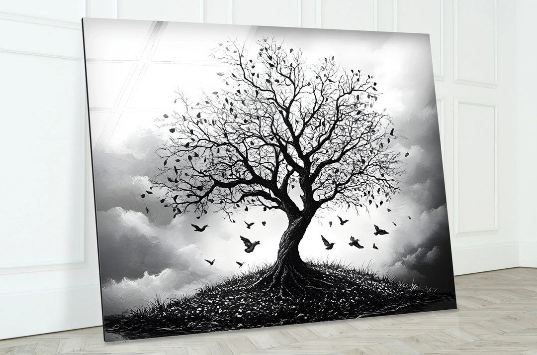 Atmospheric monochrome tree scene on glass with roots visible on a small hill and birds in motion.