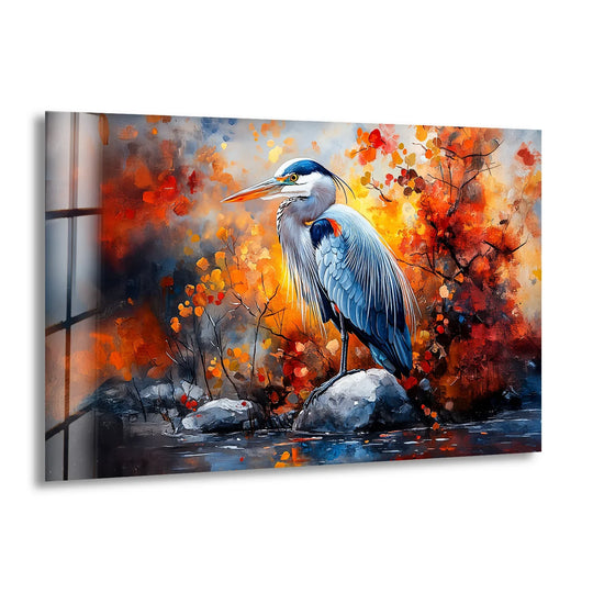 A great blue heron stands on a rock, its cool tones contrasting with the vibrant oranges and reds of fiery autumn foliage as hanging wall art.