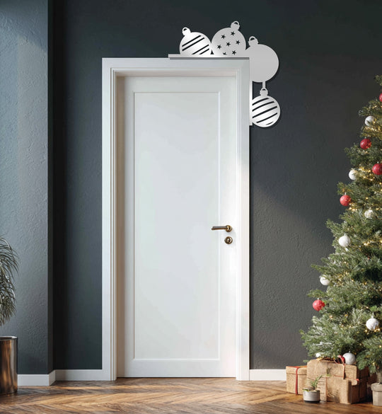 Framed by the door's edge, this metal artwork features festive Christmas ornaments adding a unique holiday border accent.