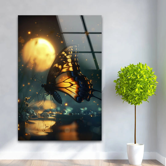 A vibrant butterfly with glowing orange and black wings against a dark, moonlit background makes striking glass wall art decor.