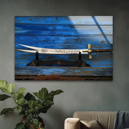 Religion Zulfikar Sword glass wall art shows gold script and a blue wooden background and is a timeless Islamic decor painting in tempered glass