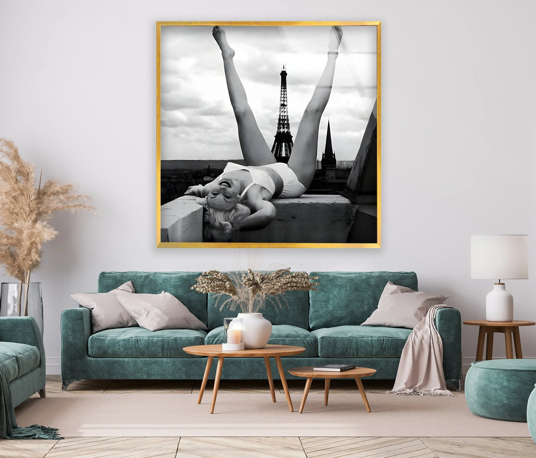 Paris-themed glass wall art featuring a relaxed woman posed above urban rooftops.