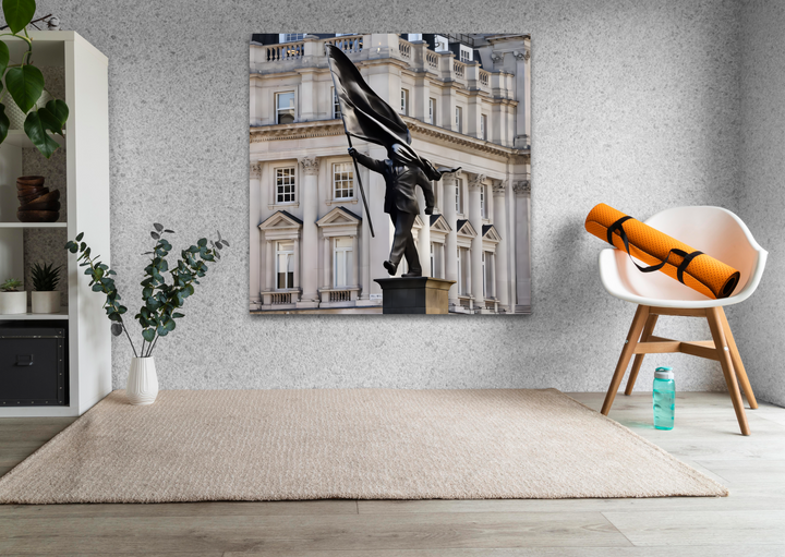 The warm beige rug on the wooden floor, white chair, orange yoga mat, and blue bottle create a serene setting for the Banksy London glass wall art decor.