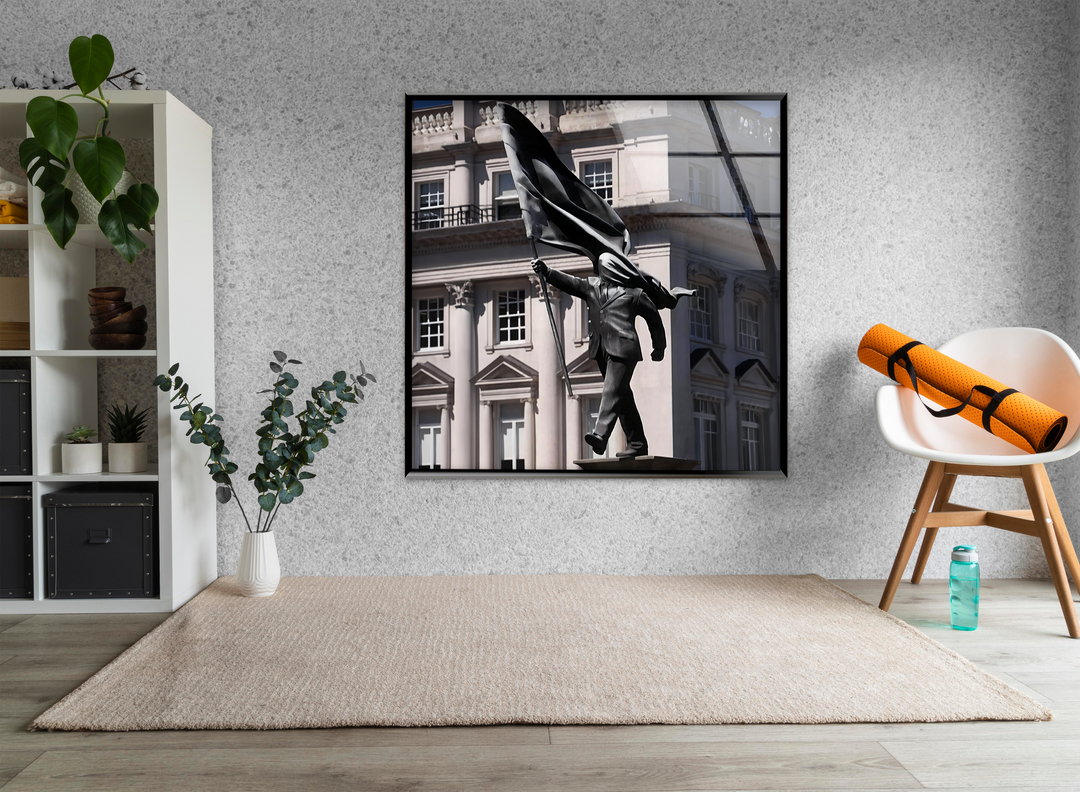 Radiant light illuminates the white building and powerful Banksy sculpture within the striking glass wall art prints.
