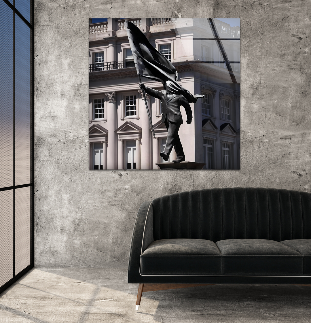 The distinct transition from the dark Banksy sculpture to the bright London architecture provides sophisticated glass wall art home decor.