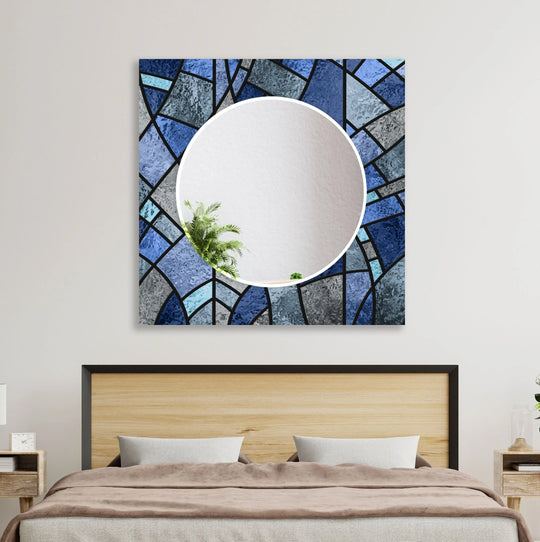 The wall mirror has a stained blue finish and geometric shapes and is modern glass décor and stylish stained glass on a white wall