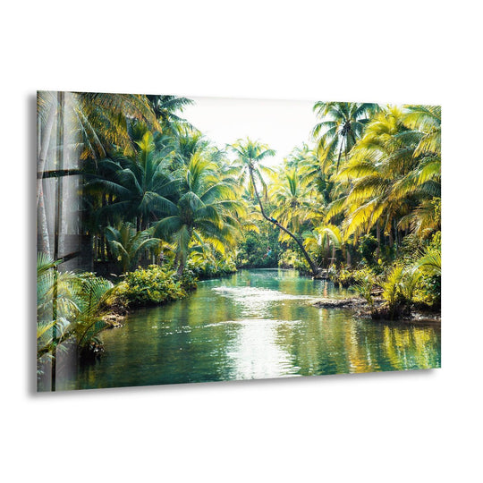 The sun-drenched jungle river, the central subject of this tropical glass wall art decor, creates a stunning landscape showcasing vibrant greenery and tall palm trees.