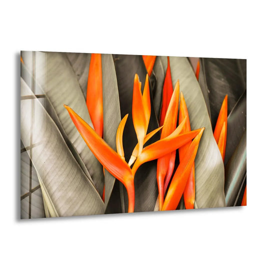 A vibrant orange tropical flower dances in a gust of wind on this eye-catching hanging wall art.